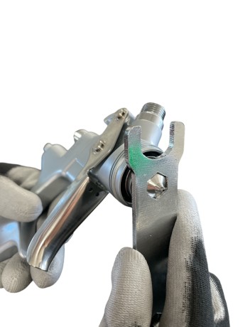 Wykręcanie dyszy malarskiej w pistolecie niskociśnieniowym przy pomocy klucza