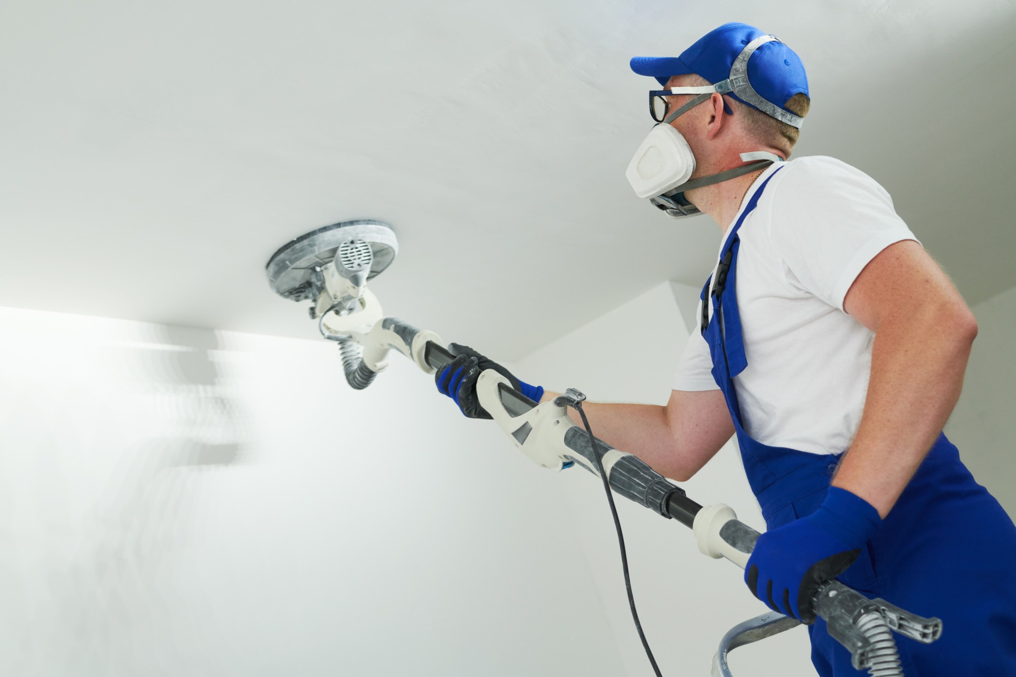 Szlifowanie sufitu za pomocą szlifierki do gipsu